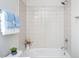 Tiled bathtub and shower area with white tile and blue towels at 732 Suffield Way, Cary, NC 27519