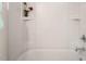 Clean shower and tub combination with white tiling and built-in shelving at 732 Suffield Way, Cary, NC 27519