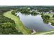 Aerial view showcases a serene lake and the surrounding landscape of a community and golf course at 763 Heritage Arbor Dr, Wake Forest, NC 27587