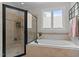 Bathroom features a glass enclosed shower and a soaking tub under a window at 763 Heritage Arbor Dr, Wake Forest, NC 27587