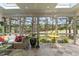 Bright sunroom features a tiled floor, a wicker sofa, and views of the golf course at 763 Heritage Arbor Dr, Wake Forest, NC 27587