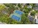 Aerial view of well-maintained tennis courts surrounded by mature trees and nearby homes at 763 Heritage Arbor Dr, Wake Forest, NC 27587