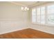 Dining room with hardwood floors, wainscoting, plantation shutters and elegant chandelier at 7646 Winners Edge St, Raleigh, NC 27617