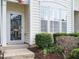 Close-up of the front entrance, showcasing a modern glass door and manicured garden beds at 7646 Winners Edge St, Raleigh, NC 27617