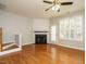 Bright living room featuring a fireplace, ceiling fan, hardwood floors and access to the backyard at 7646 Winners Edge St, Raleigh, NC 27617