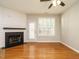 Living room featuring a fireplace, ceiling fan, hardwood floors and a view of the backyard at 7646 Winners Edge St, Raleigh, NC 27617