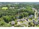 Aerial view of a neighborhood with a pond nestled among lush greenery and mature trees at 825 Highwater Pl, Fuquay Varina, NC 27526