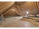 An expansive attic space with exposed beams and a small window at 825 Highwater Pl, Fuquay Varina, NC 27526
