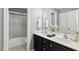 Bathroom featuring double vanity, framed mirrors and tub with glass door at 825 Highwater Pl, Fuquay Varina, NC 27526