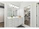 Bathroom vanity with a large mirror and door leading to a walk-in closet at 825 Highwater Pl, Fuquay Varina, NC 27526