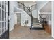 Spacious foyer with staircase featuring iron spindles and tile flooring, creating an elegant entrance at 825 Highwater Pl, Fuquay Varina, NC 27526