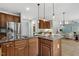 Open concept kitchen with stainless fridge and island with granite countertops and breakfast bar seating at 825 Highwater Pl, Fuquay Varina, NC 27526