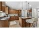 Open kitchen featuring granite countertops, stainless appliances, kitchen island with breakfast bar, and wood cabinets at 825 Highwater Pl, Fuquay Varina, NC 27526
