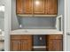 Kitchenette with custom wood cabinets, white countertop, undermount sink, and modern fixtures at 825 Highwater Pl, Fuquay Varina, NC 27526