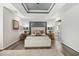 Well-lit main bedroom with tray ceilings, a neutral color palette and ensuite bathroom at 825 Highwater Pl, Fuquay Varina, NC 27526