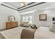 Bright main bedroom boasts a tray ceiling, area rug, dresser, and seating area at 825 Highwater Pl, Fuquay Varina, NC 27526