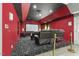 Basement theater room with projector, tiered seating, and vibrant red accent wall at 825 Highwater Pl, Fuquay Varina, NC 27526