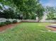 Wide view of a lush, green backyard with a white picket fence at 9020 Branch Creek Way, Apex, NC 27539