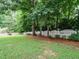 A lush green lawn is surrounded by a white picket fence and mature trees, offering privacy at 9020 Branch Creek Way, Apex, NC 27539