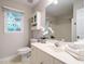 Well-lit bathroom featuring white vanity, matching toilet, and an decorative orchid at 9020 Branch Creek Way, Apex, NC 27539