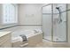 Bright bathroom featuring a soaking tub and a glass-enclosed shower at 9020 Branch Creek Way, Apex, NC 27539