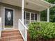 Inviting front entryway with brick steps, a black front door, and a white-railed porch at 9020 Branch Creek Way, Apex, NC 27539
