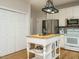 Well-equipped kitchen boasts an island, stainless steel appliances, and white cabinetry at 9020 Branch Creek Way, Apex, NC 27539