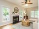Bright living room featuring a fireplace, large windows, hardwood floors, and stylish furnishings at 9020 Branch Creek Way, Apex, NC 27539