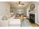 Cozy living room with a fireplace, hardwood floors, neutral furniture, and large windows at 9020 Branch Creek Way, Apex, NC 27539