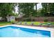Private backyard pool with lush greenery, planters and shed at 907 Stuart Dr, Mebane, NC 27302