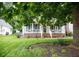 Charming home with a covered front porch, white pillars, and a well-manicured lawn at 907 Stuart Dr, Mebane, NC 27302