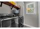 Modern laundry room with front loading washer and dryer and overhead shelving at 907 Stuart Dr, Mebane, NC 27302