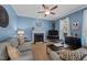 Charming living room with blue walls, fireplace, ceiling fan, and comfortable seating at 907 Stuart Dr, Mebane, NC 27302