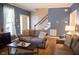 Well-lit living room with hardwood floors, comfortable seating, and view of the staircase at 907 Stuart Dr, Mebane, NC 27302