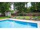 Backyard pool with surrounding patio and lush green landscape at 907 Stuart Dr, Mebane, NC 27302
