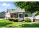 Back of the house featuring a sunroom, a deck with seating, and a well-maintained lawn at 907 Stuart Dr, Mebane, NC 27302