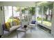Enclosed sunroom featuring comfortable seating and views of the lush backyard at 907 Stuart Dr, Mebane, NC 27302
