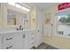 Bright bathroom featuring a white vanity with sleek black fixtures, window and neutral paint at 9964 N Chestnut St, Middlesex, NC 27557