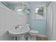 Bright bathroom features a pedestal sink, white tile walls, and a window with natural light at 9964 N Chestnut St, Middlesex, NC 27557