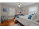 Inviting bedroom boasts hardwood floors, natural light, and tranquil decor with a blue accent pillow at 9964 N Chestnut St, Middlesex, NC 27557