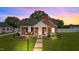 Charming brick home with a well-manicured lawn and cozy front porch at sunset at 9964 N Chestnut St, Middlesex, NC 27557