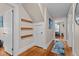 Hallway with hardwood floors, storage under the stairs, and neutral paint at 9964 N Chestnut St, Middlesex, NC 27557
