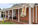 Inviting front porch with a porch swing, potted plants, and brick siding at 9964 N Chestnut St, Middlesex, NC 27557