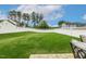 Expansive, well-maintained backyard featuring a pristine lawn and white vinyl fence for privacy at 100 Emory Bluffs Dr, Holly Springs, NC 27540