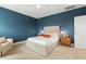 Bedroom boasts an upholstered bed, blue accent wall, and bedside tables at 100 Emory Bluffs Dr, Holly Springs, NC 27540