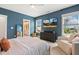 Bedroom with upholstered bed, accent wall, and a large window with a view at 100 Emory Bluffs Dr, Holly Springs, NC 27540