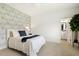 Bright bedroom with patterned accent wall, white bedding, and an ensuite bathroom at 100 Emory Bluffs Dr, Holly Springs, NC 27540