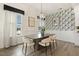 Stylish dining room with modern chandelier, dining table, chairs, and decorative wallpaper at 100 Emory Bluffs Dr, Holly Springs, NC 27540