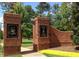Brick entrance to The 12 Oaks Club with signage and landscaped surroundings on a sunny day at 100 Emory Bluffs Dr, Holly Springs, NC 27540