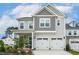Charming two-story home with a two-car garage, covered porch, and landscaped front yard at 100 Emory Bluffs Dr, Holly Springs, NC 27540